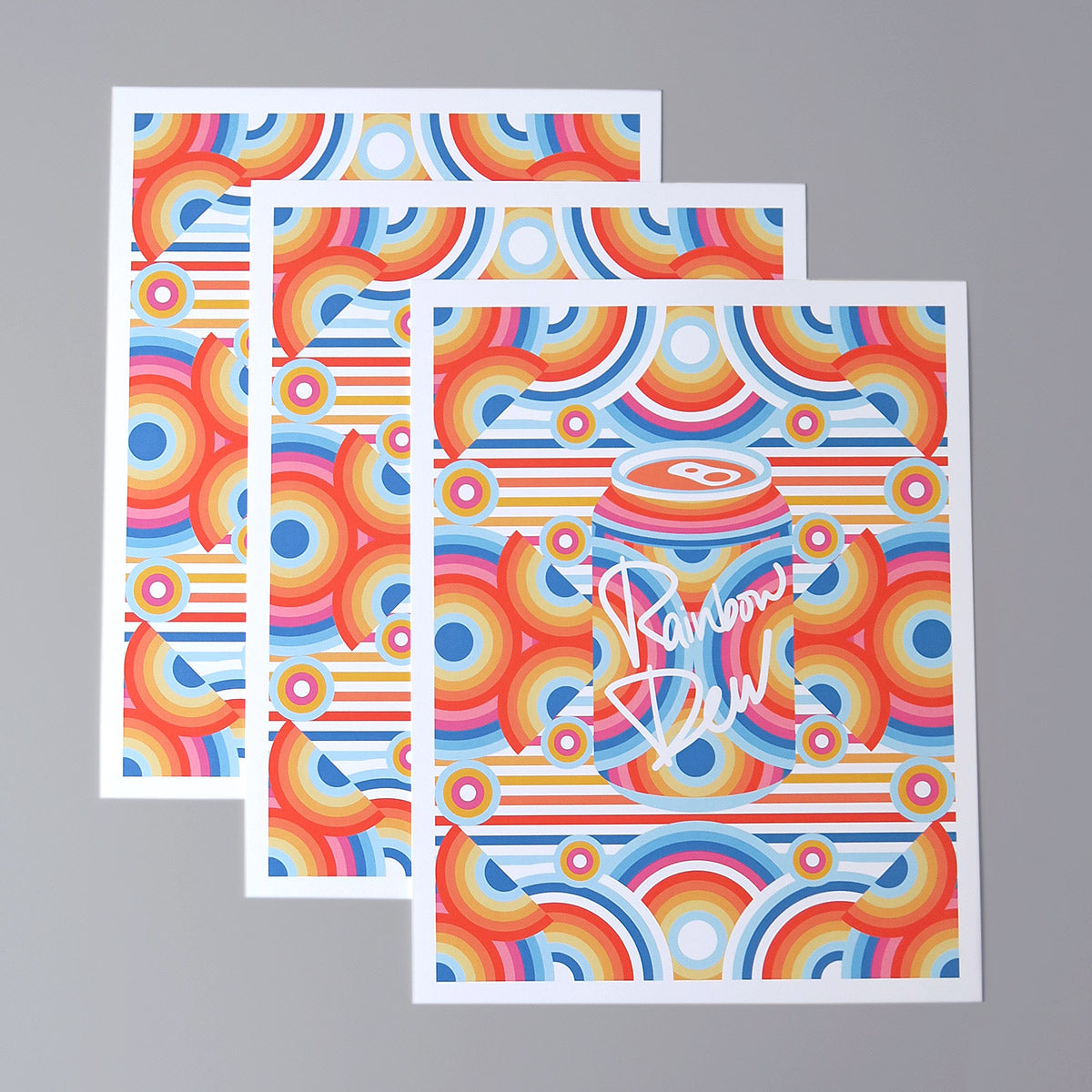 Rainbow Dew is a pop art print that has a multitude of colours. Red, blue, yellow, magenta, sun flower yellow. There are concentric circles that are arranged in a radial way with a drink can in the centre.